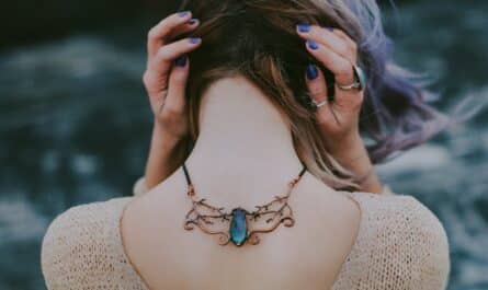 woman wears gold colored blue gemstone pendant necklace