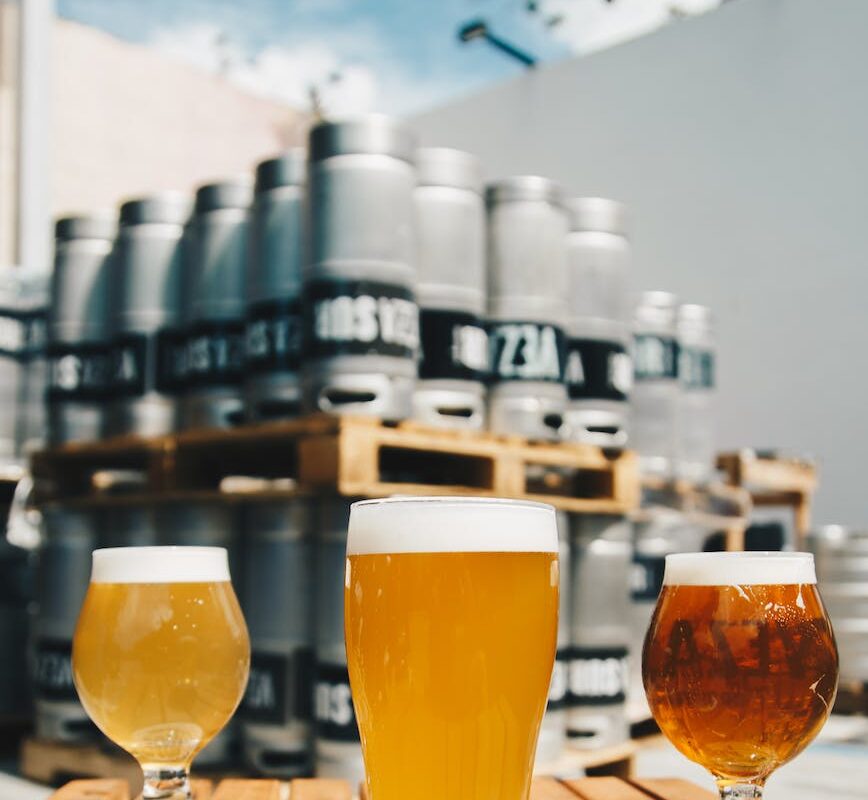 three assorted drinking glasses with beer