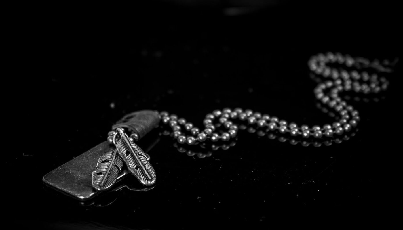 silver dog tag necklace on black background