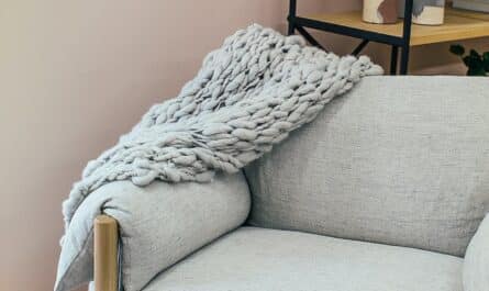 armchair with plaid near shelves in room