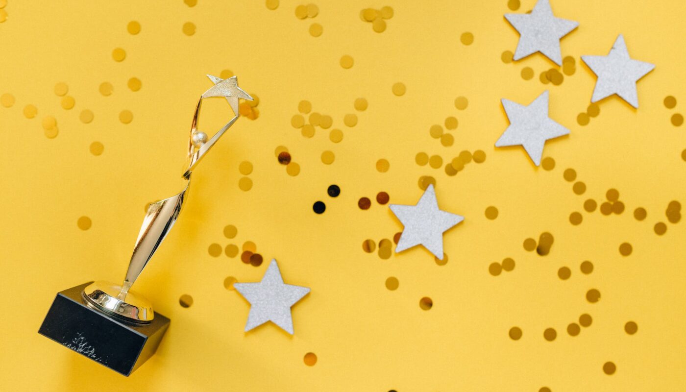 golden statuette and stars on yellow background