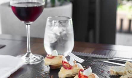 delicious food served on table with glass of red wine
