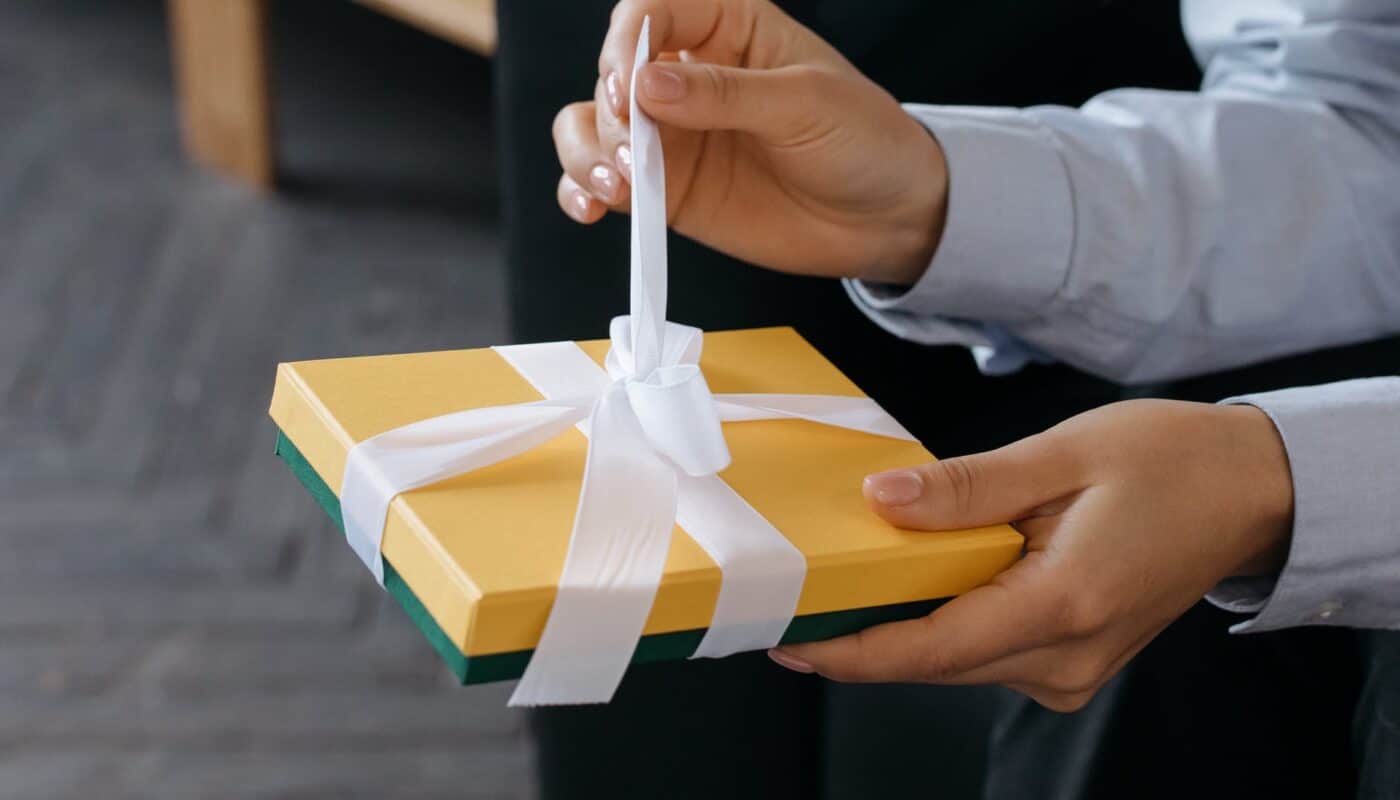 a person untying the ribbon on a gift box