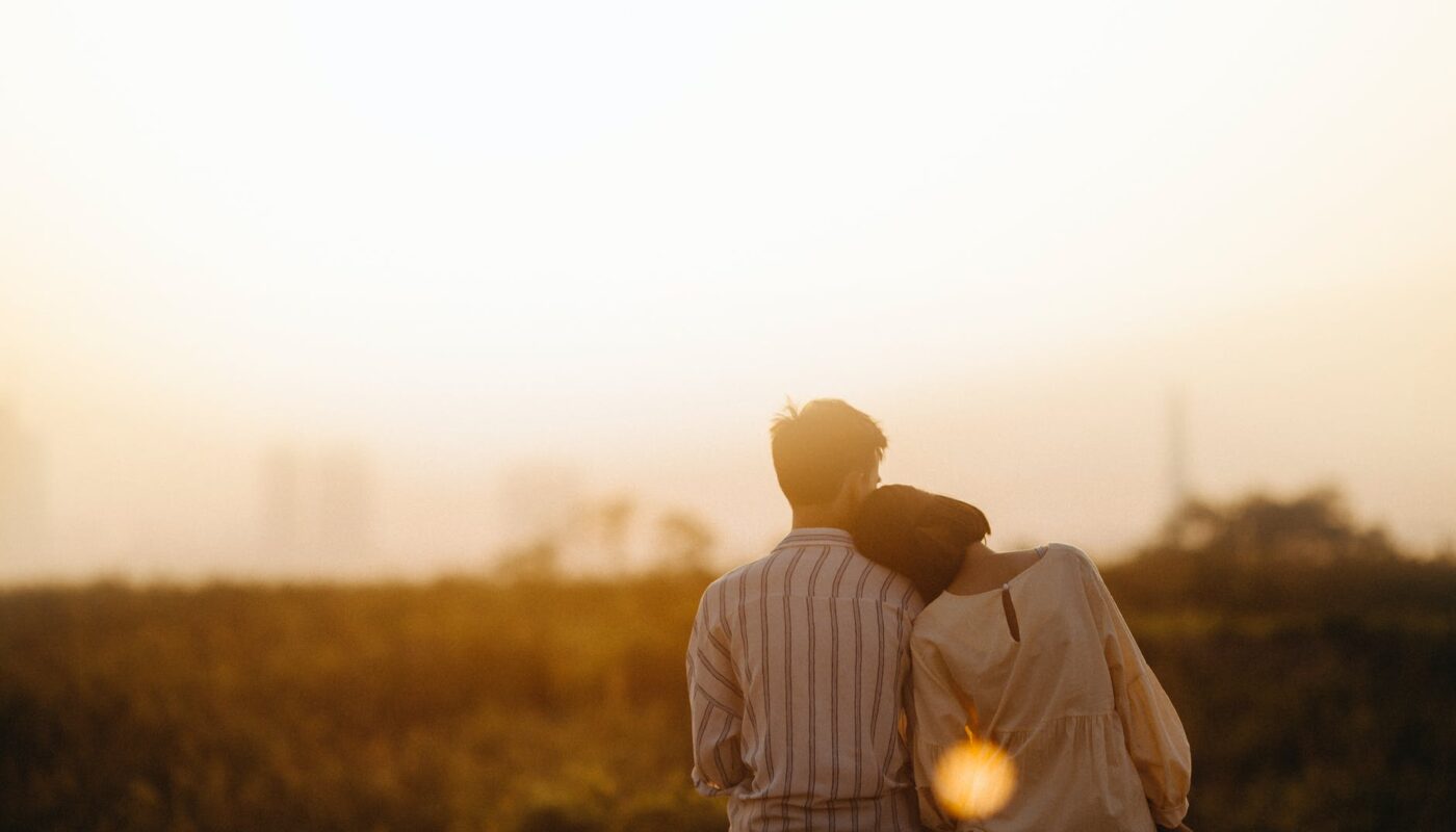 man and woman near grass field