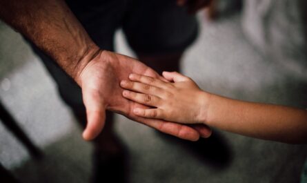 selective focus photography of child s hand