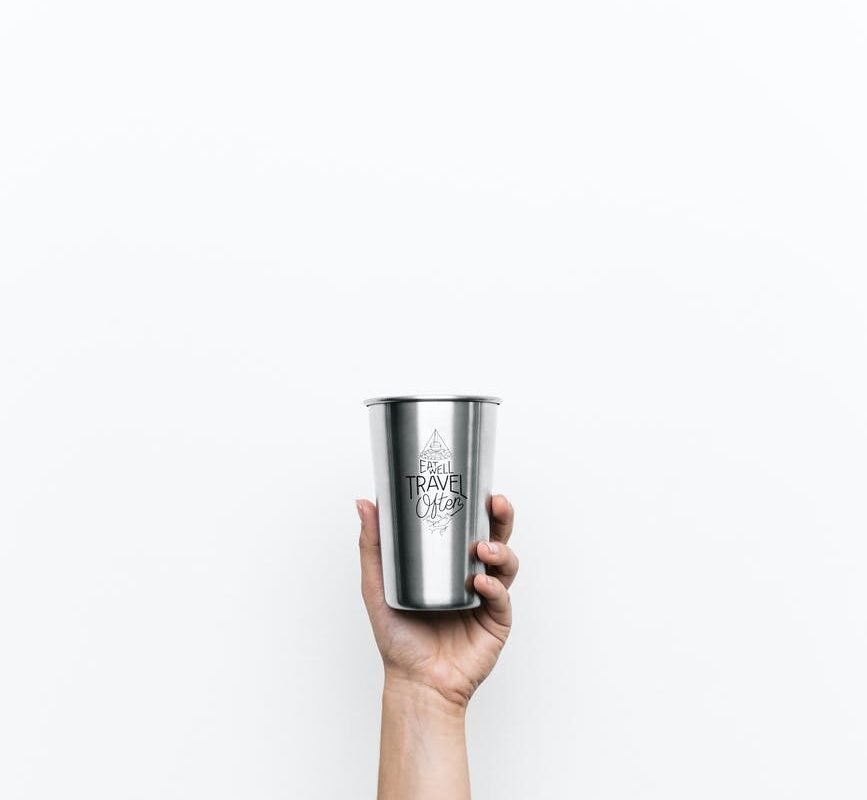 person holding gray cup