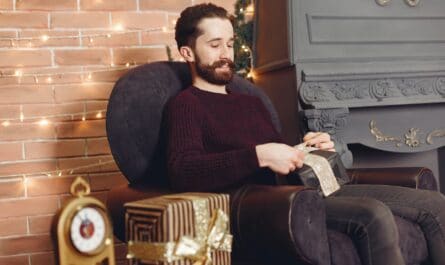man sitting in armchair with christmas present