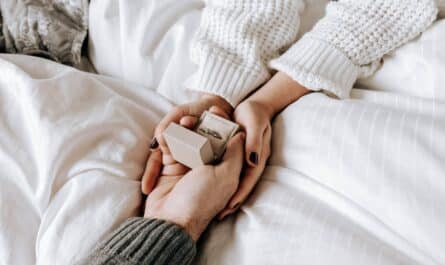 crop faceless man making proposal and presenting ring to girlfriend