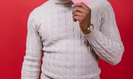 man in white sweater holding a valentine s day card