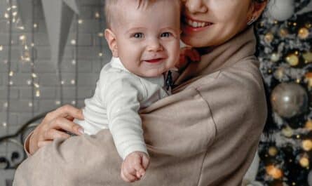 portrait of smiling mother and child near fir tree