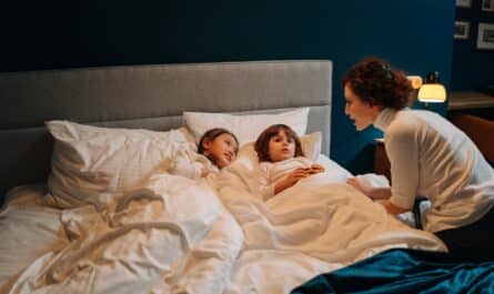 woman telling story to two children in bed
